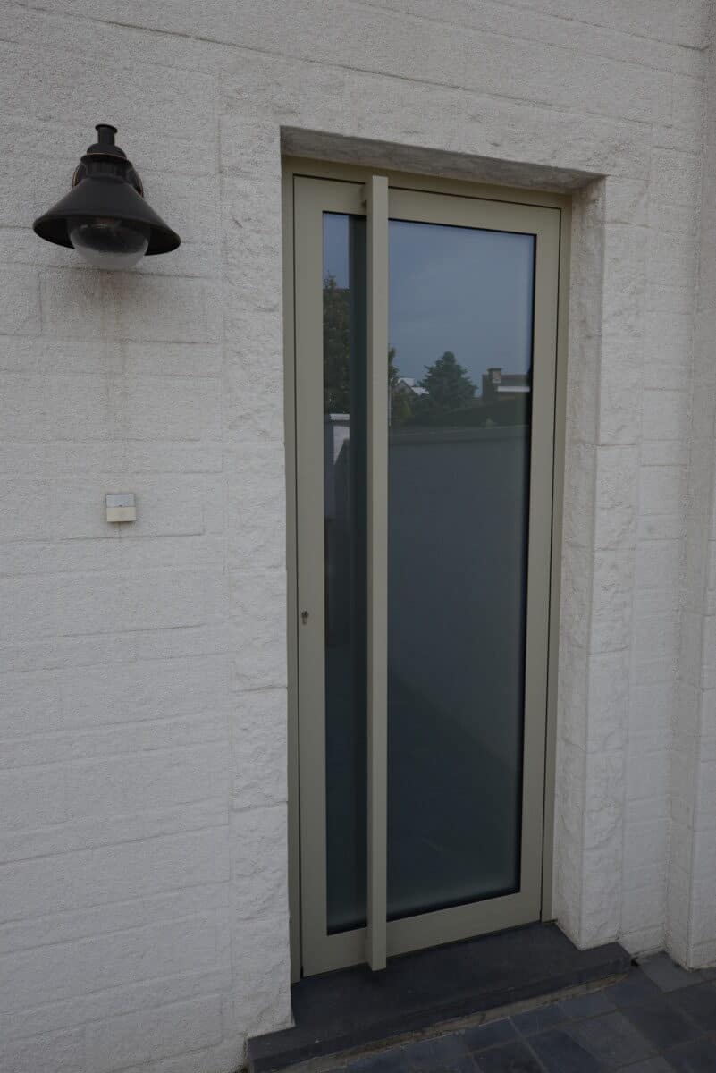 Modern aluminium buitendeur met groot glasvlak en beige kader geïnstalleerd door Alumar