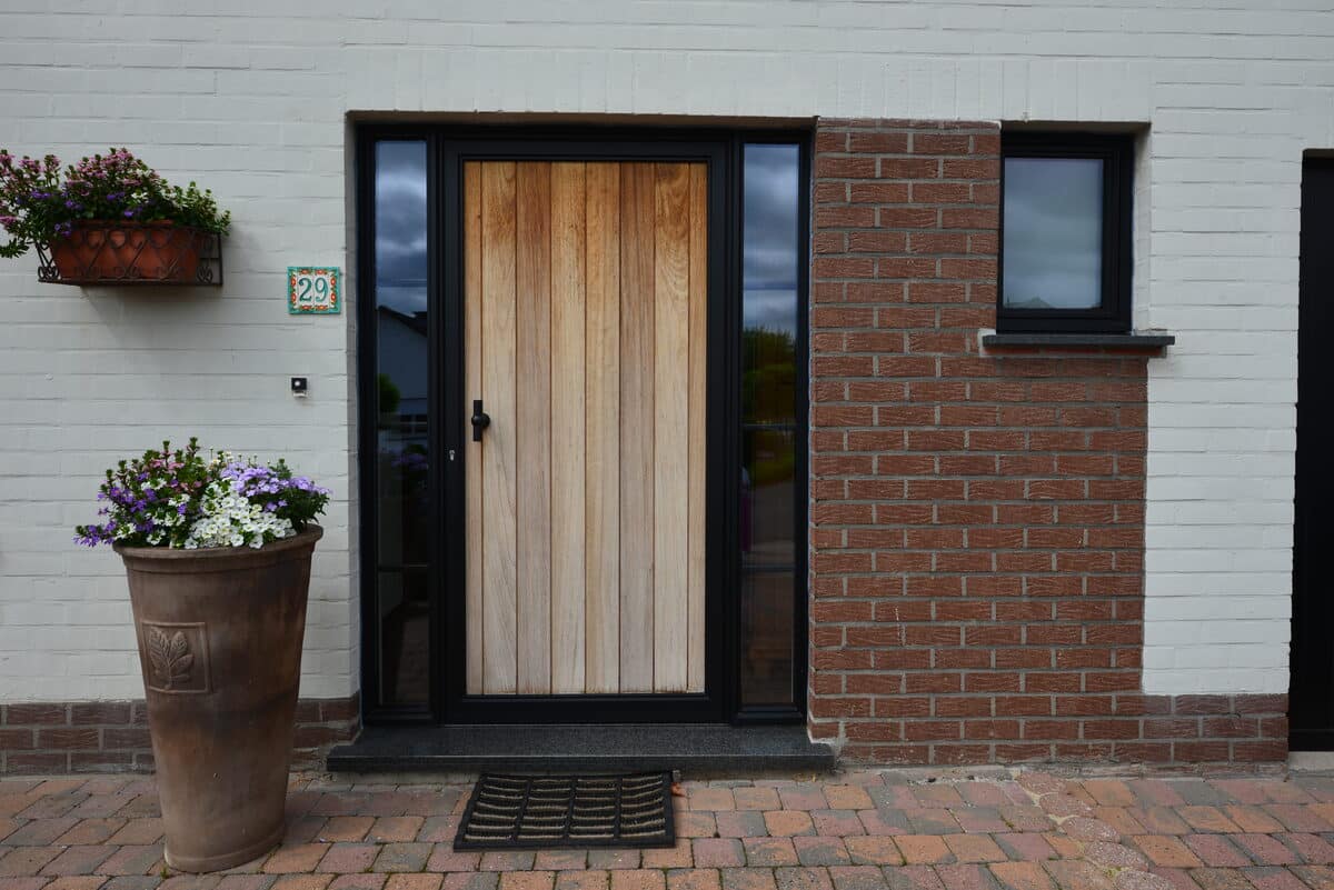 Houten voordeur met zwart steellook kader en zijlicht