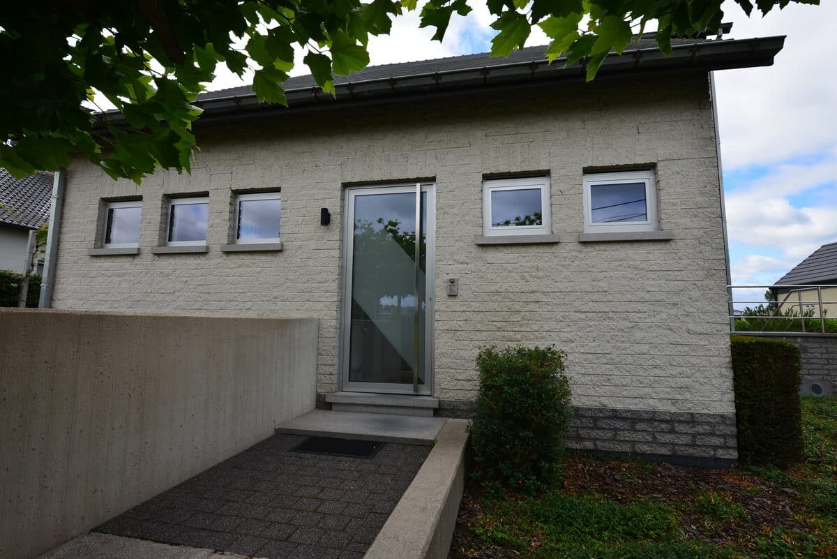 Witte bungalow met witte aluminium ramen en een glazen voordeur